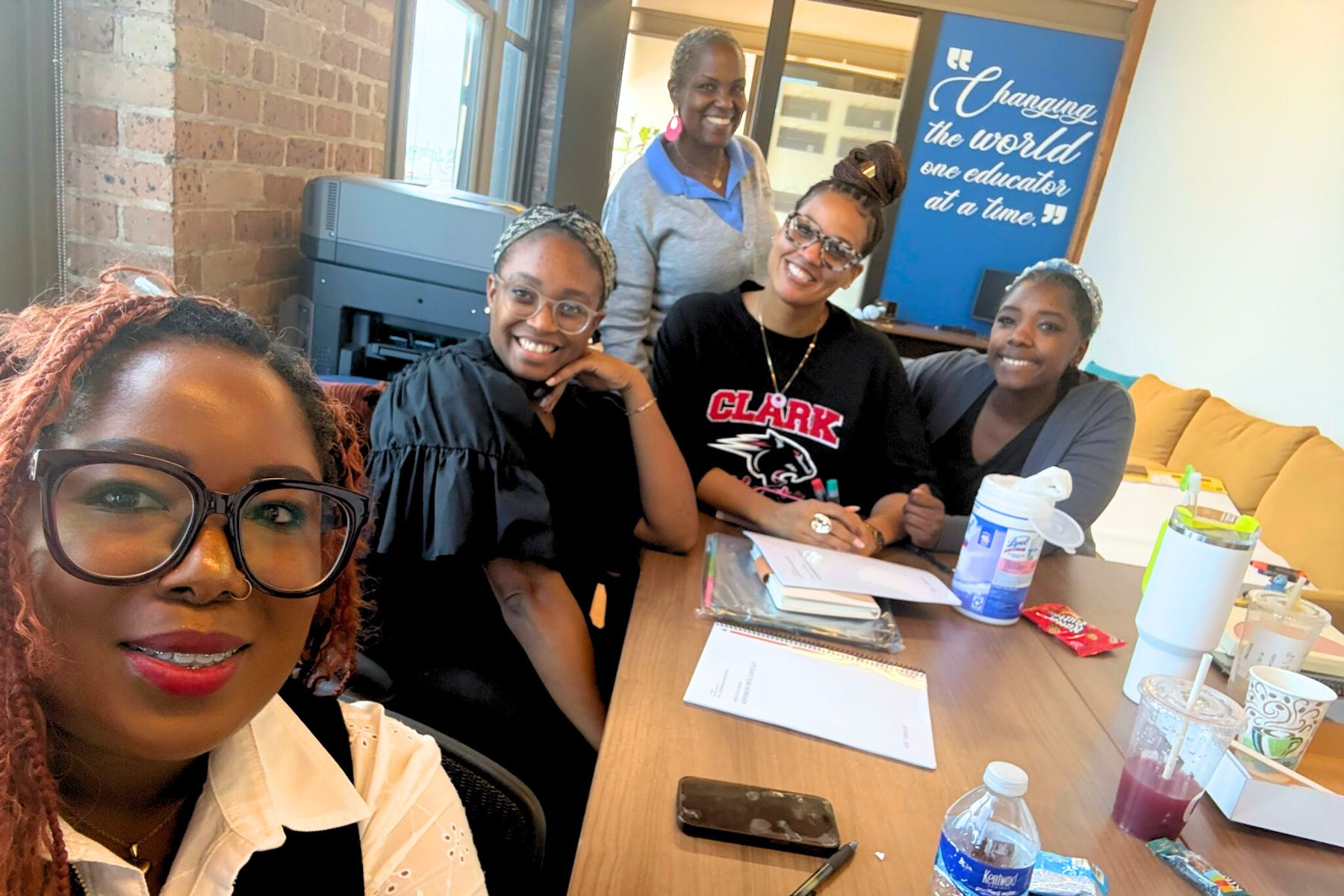 Niki Da’Jon, MBA, with a small group of educators at a conference table, smiling.
